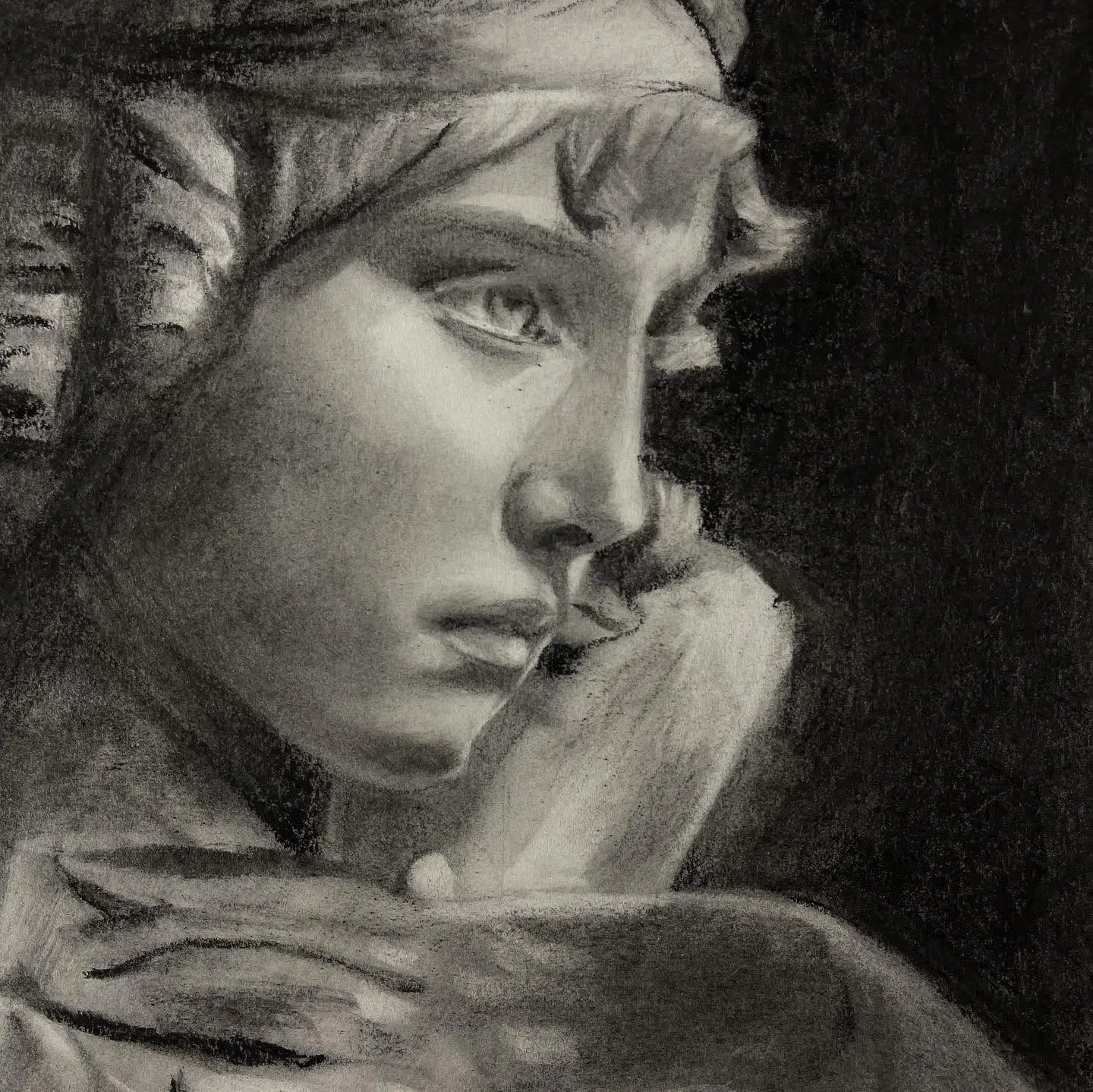 Charcoal study of a woman's face resting on her hand