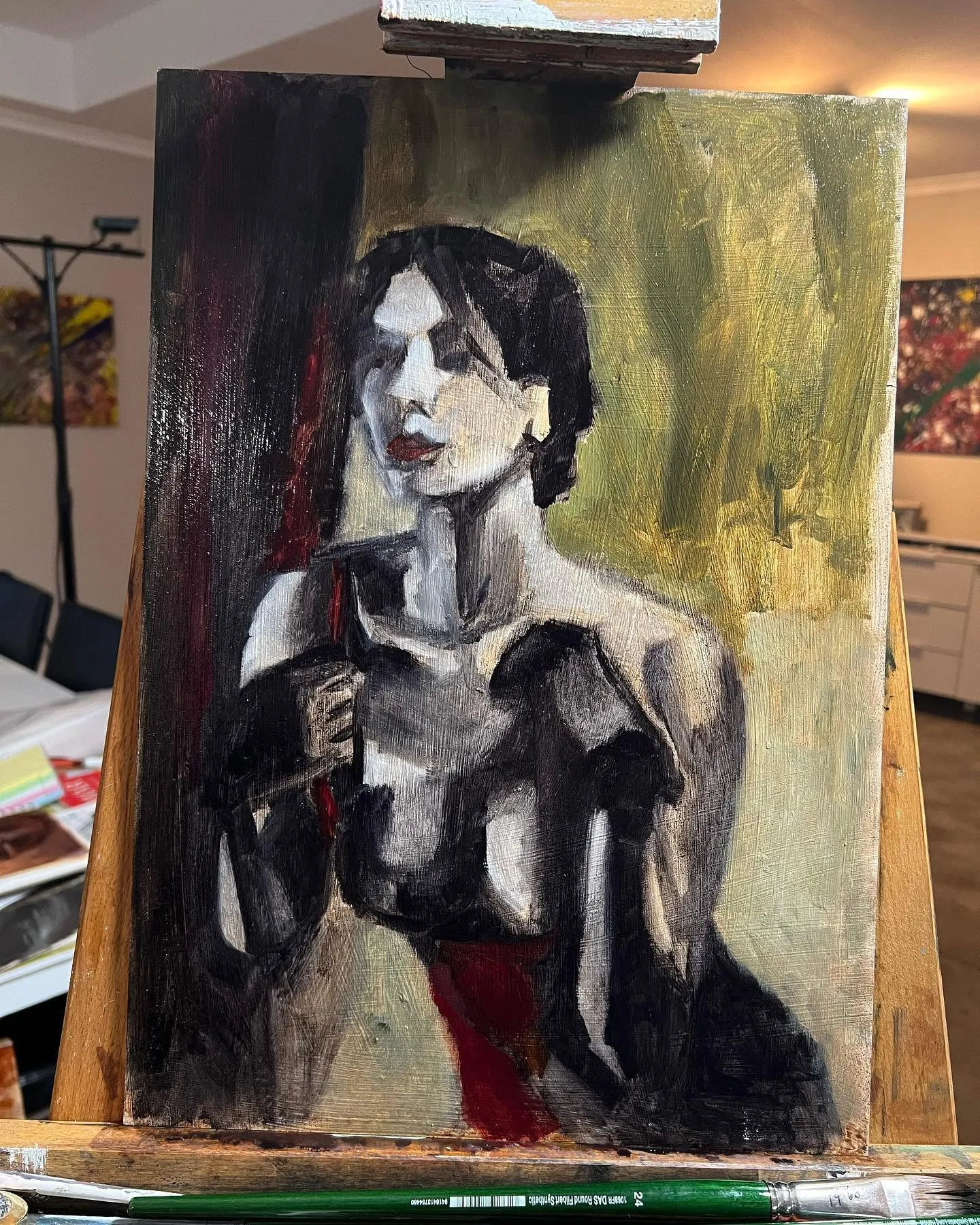 Oil painting of a woman in a dark dress, on the easel