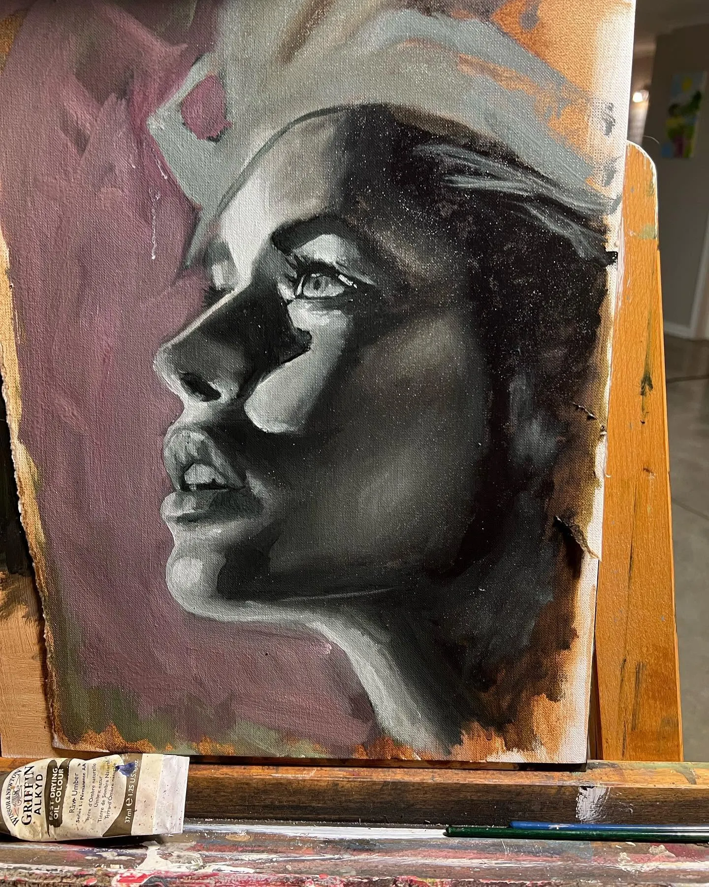 Oil painting of a woman in profile, on the easel