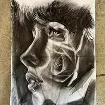 Charcoal portrait of a face in profile with a rose
