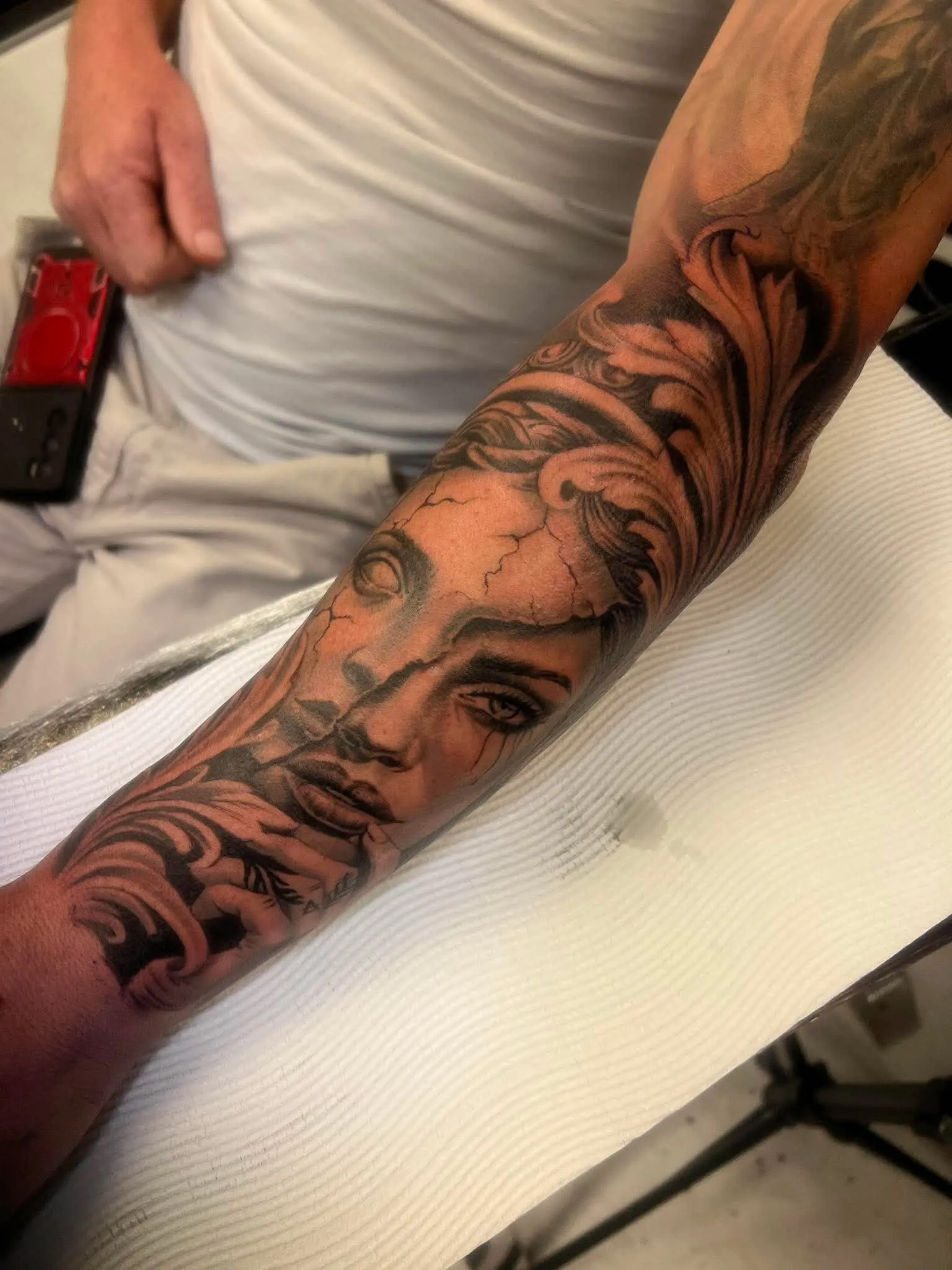Black and grey realism forearm piece of a woman's face