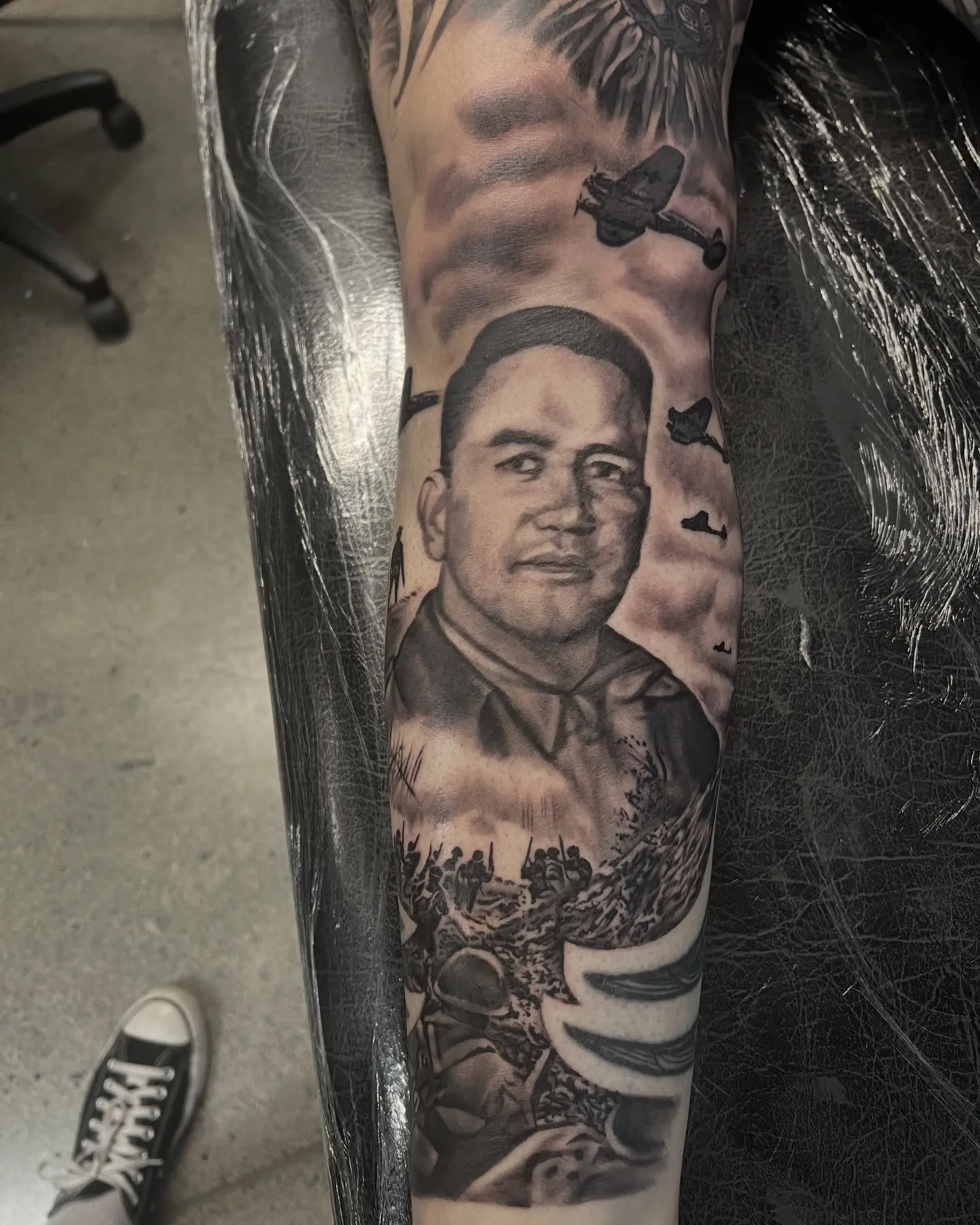 Black and grey realism portrait of a man as part of a leg sleeve