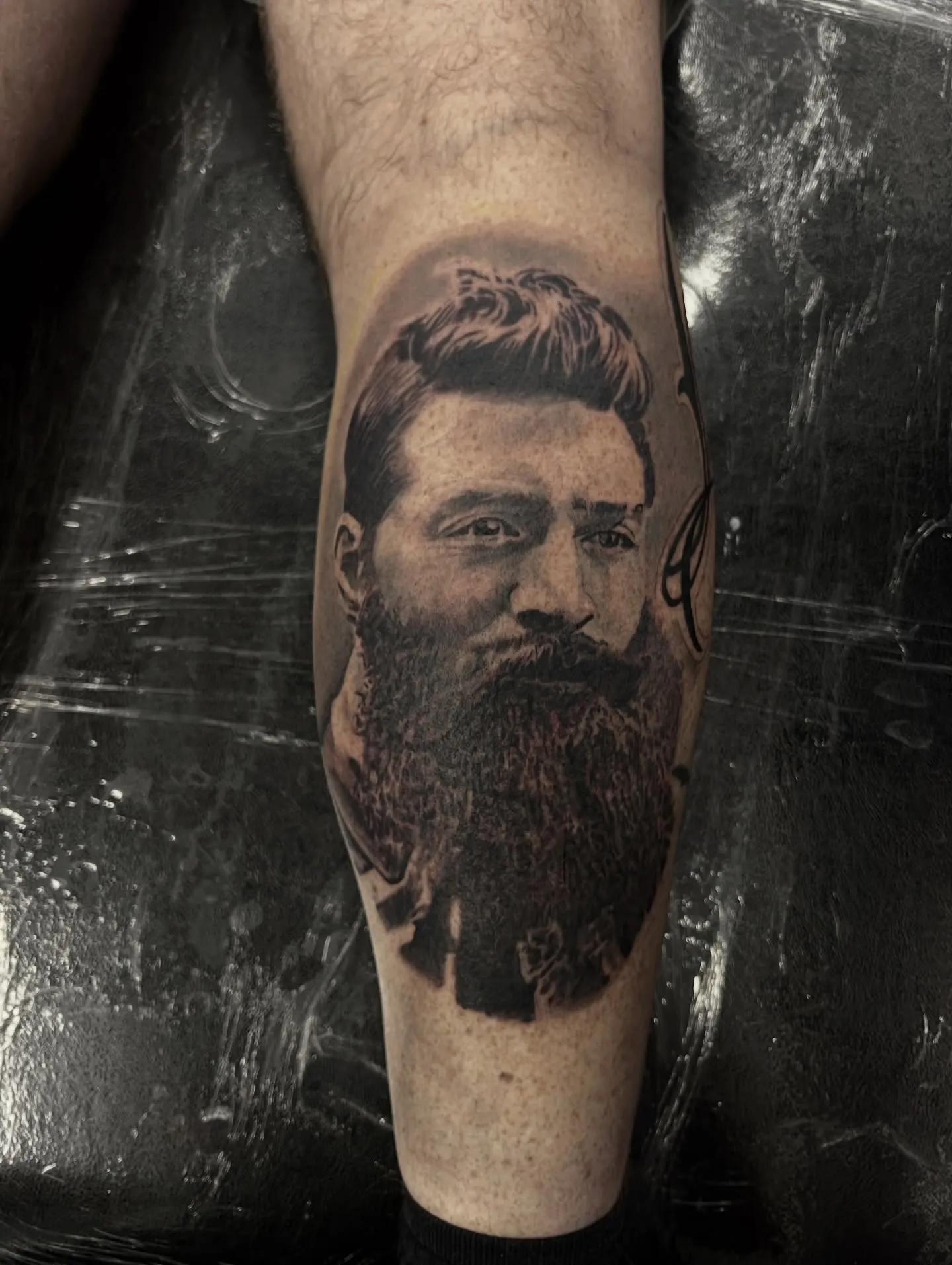 Black and grey realism portrait of a bearded man on the calf